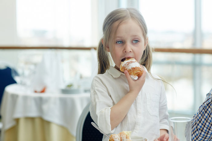 Young girl eating pastry indoors, representing themes of neglectful mom and family conflict over CPS intervention.