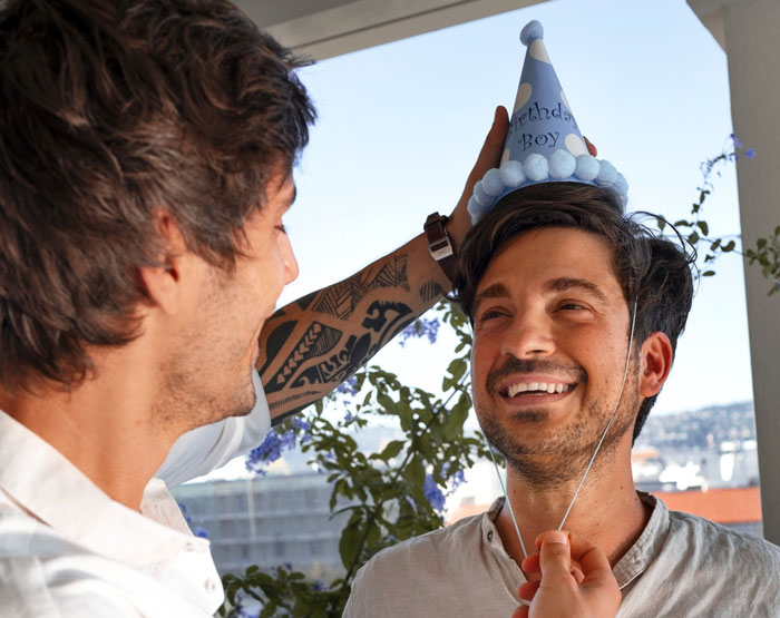 Two men celebrating with one wearing a birthday hat, highlighting a best friend's 35th birthday event.