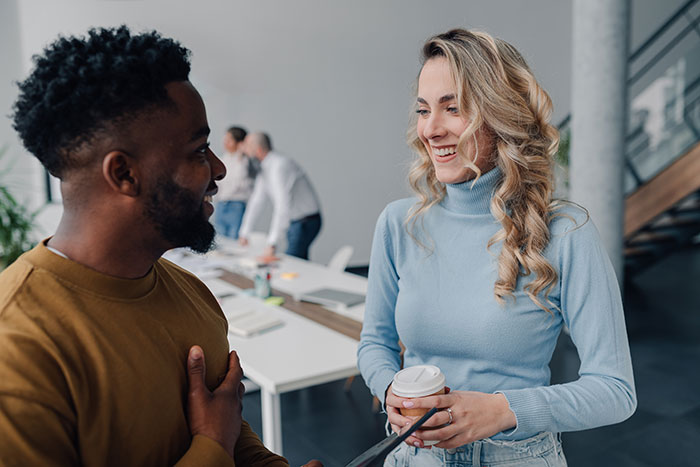 Person disappointed in boss they looked up to talking with employee in modern office setting during work hours