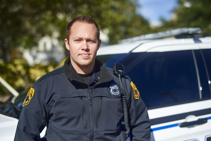 Police officer standing confidently near a patrol car, illustrating lawyers' surprising legal information moments.