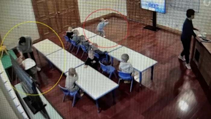 Surrogate in a classroom setting with children and an adult, illustrating a story about a surrogate suing a couple.