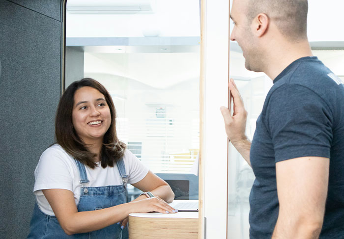 Young woman smiling and talking to a man in casual clothes, illustrating man-child behaviors in relationships.
