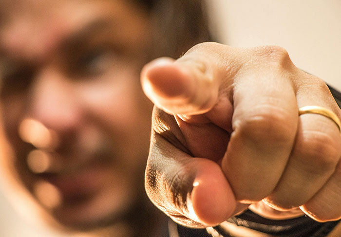 Close-up of a man pointing forward, illustrating behaviors of a man-child in a personal interaction context.