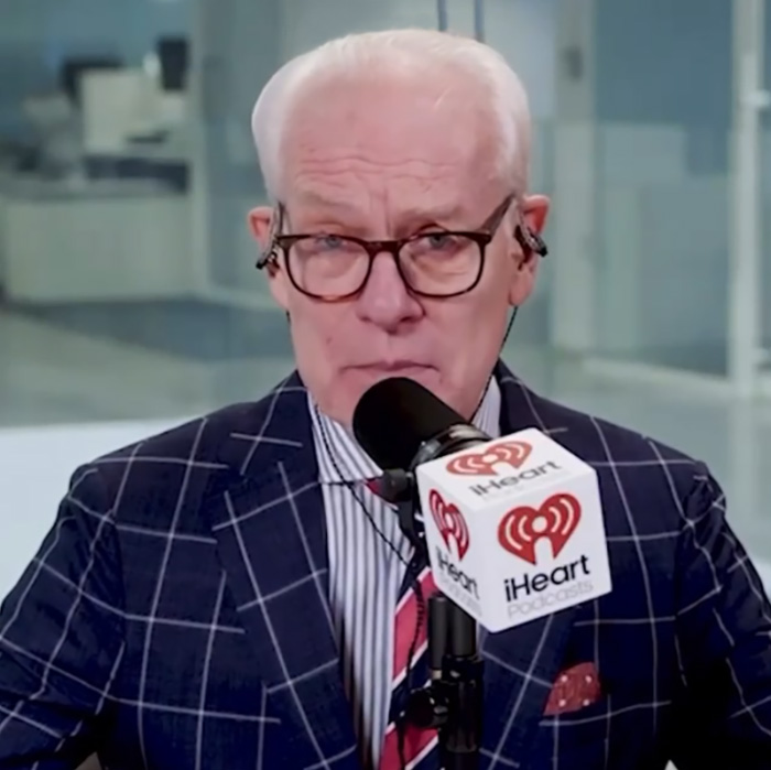 Tim Gunn speaking into a microphone during an iHeart podcast, discussing celibacy and personal reflections.