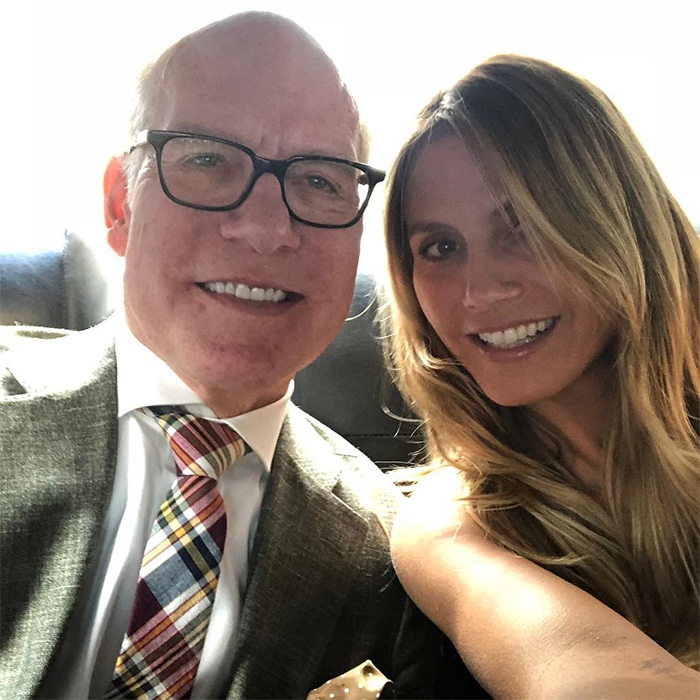 Tim Gunn smiling in glasses and a plaid tie, posing with a woman, relating to celibacy and personal reasons.