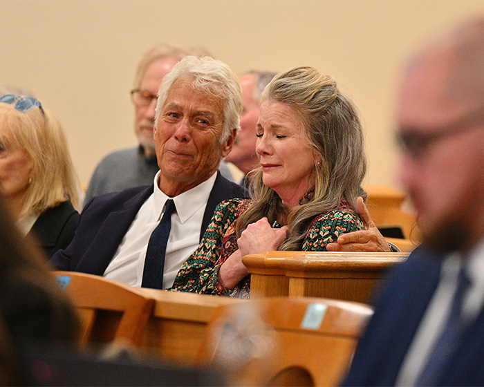 Timothy Busfield in court looking emotional with a woman, surrounded by people during serious child case proceedings.