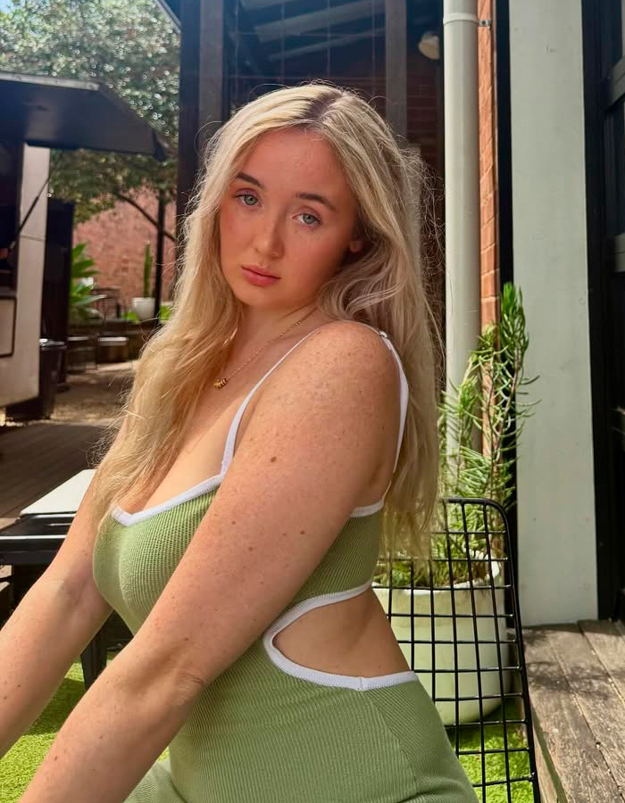 Young woman in a green dress sitting outdoors, related to tourist's response to being caught on camera stealing a bikini. Young woman in a green dress sitting outdoors, related to tourist's response to being caught on camera stealing a bikini.
