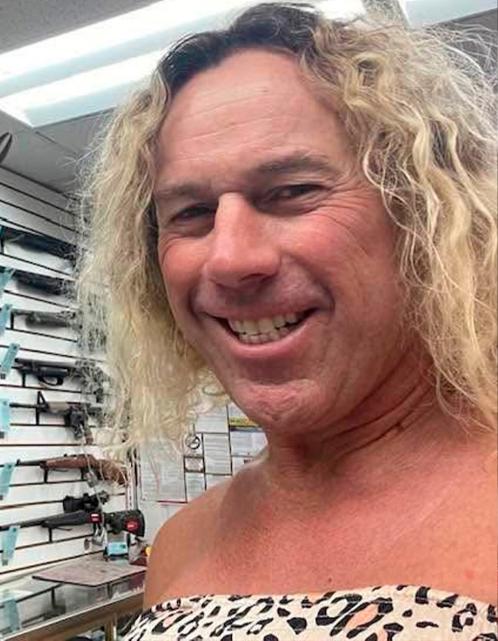 Man with long curly hair smiling inside a store, police discover disturbing detail about ice rink attacker's family.