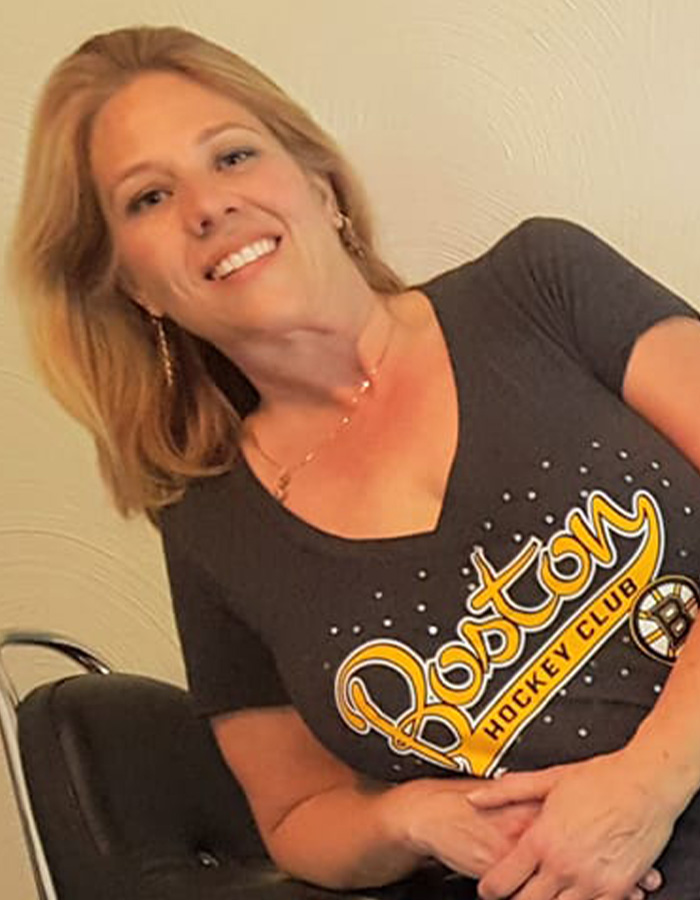 Smiling woman wearing a Boston Hockey Club shirt, related to police discovering disturbing detail about ice rink attacker family.