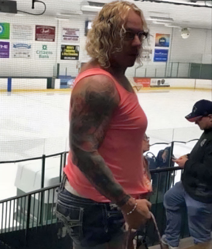 Person with tattoos and glasses standing inside an ice rink, related to police discovery about ice rink attacker&rsquo;s family.