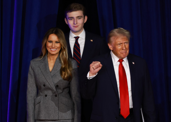 Donald Trump with Melania and Barron Trump posing at an event, highlighting Barron&rsquo;s height in a viral family photo.