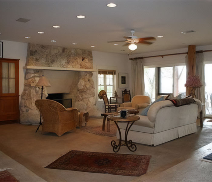 Cozy living room with stone fireplace and wicker chair highlighting debate over money management and GoFundMe campaigns.