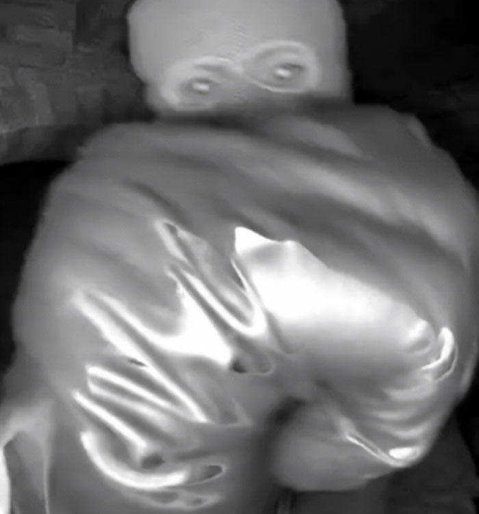 Blurry black and white image showing a figure in a hooded jacket linked to police investigation in Nancy Guthrie kidnapping video.