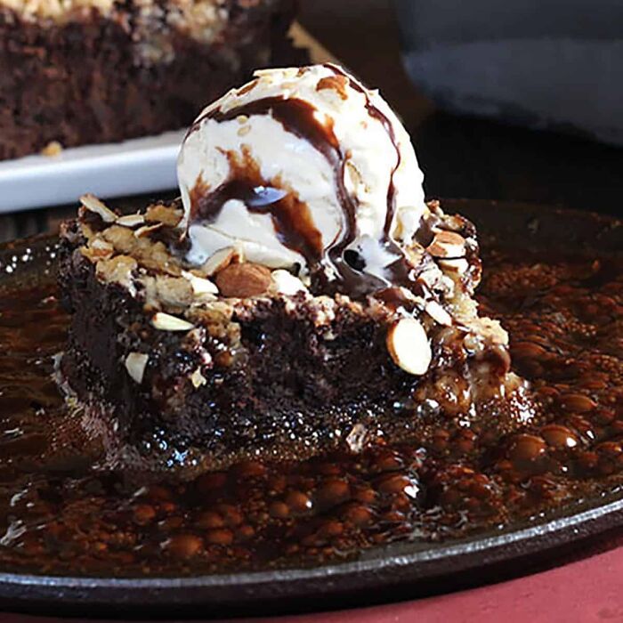 Chocolate brownie topped with ice cream and nuts, showcasing a popular dessert people thought was common everywhere.