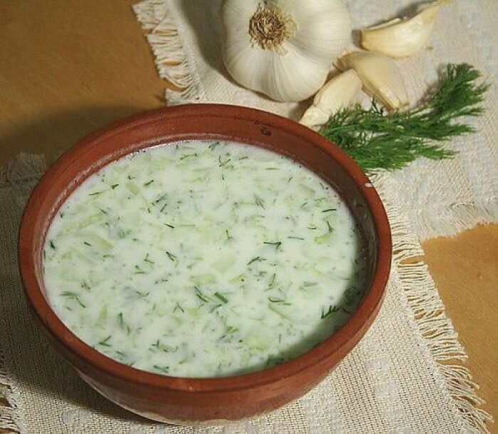 Traditional garlic and herb soup in a clay bowl, showcasing unique cultural food items not common everywhere.