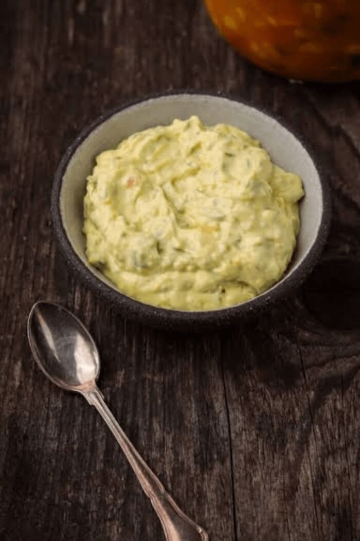 Bowl of creamy homemade sauce on rustic wooden table with spoon, showing things people think are common everywhere.