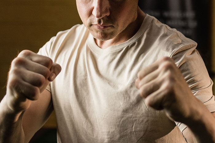 Man with clenched fists and focused expression, representing the lives of ultra-popular guys in adulthood.