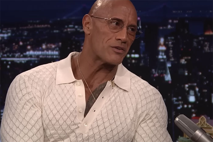 Man in glasses wearing a white patterned shirt discussing how the lives of ultra-popular guys unfolded in adulthood on a talk show.