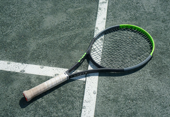 Tennis racket lying on a court surface, illustrating a metaphor for unhinged workplace incidents and job challenges.