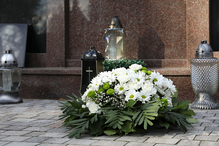 Wreath of white flowers and lanterns at a gravesite symbolizing family conflict over teen calling stepdad dad. Wreath of white flowers and lanterns at a gravesite symbolizing family conflict over teen calling stepdad dad.