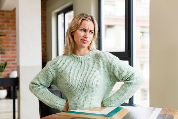 Woman judging coworker&rsquo;s life choices with a disapproving expression, overlooking her own conflicting morals.