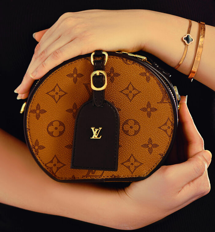 Hands holding a luxury designer handbag, symbolizing outrageous displays of entitlement and impatience.