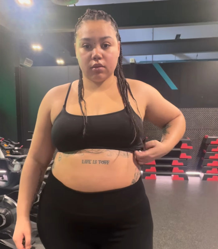 Bridgerton actress in gymwear showing mental health impact on her body with visible tattoos and serious expression.