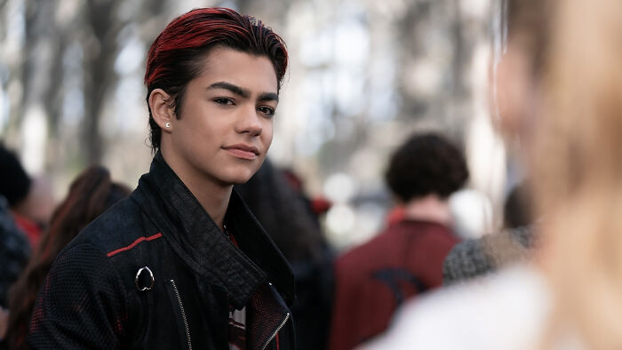 Young male cast member outdoors with dark jacket and red highlights, related to Zombies 5 release date, cast, and plot updates.