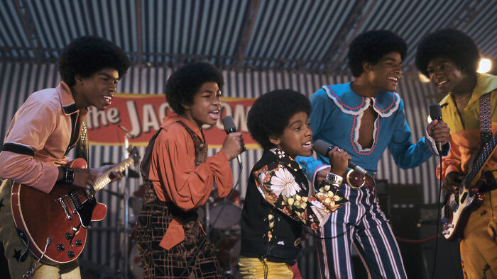 Young male cast members performing on stage in the Michael Movie cast portraying Michael Jackson and bandmates.