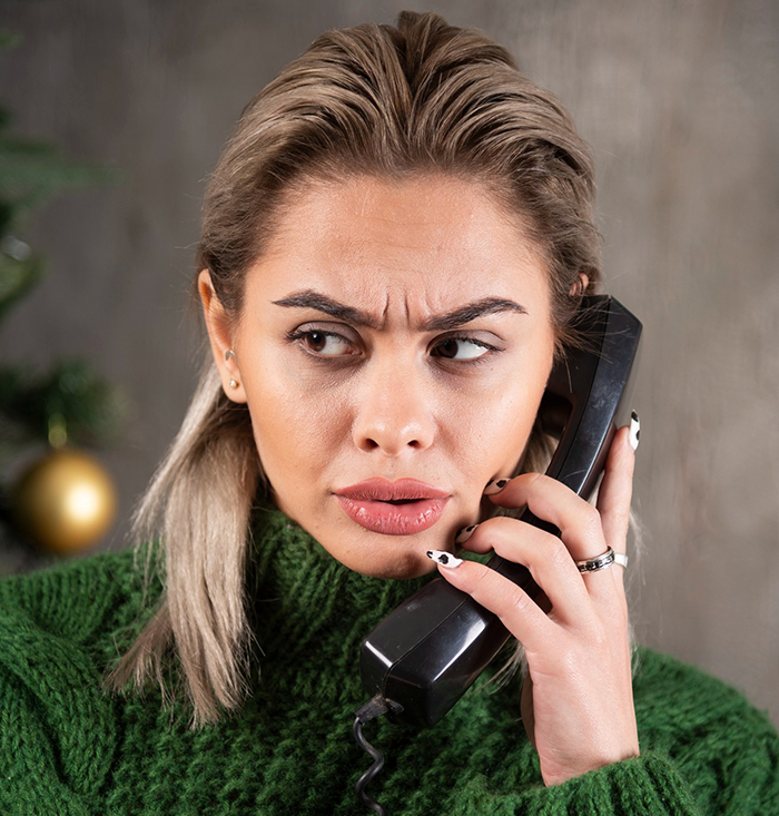 Mulher com expressão preocupada segurando um telefone, reagindo a um funcionário revelando acidentalmente uma amante causando o caos. Mulher com expressão preocupada segurando um telefone, reagindo a um funcionário revelando acidentalmente uma amante causando o caos.