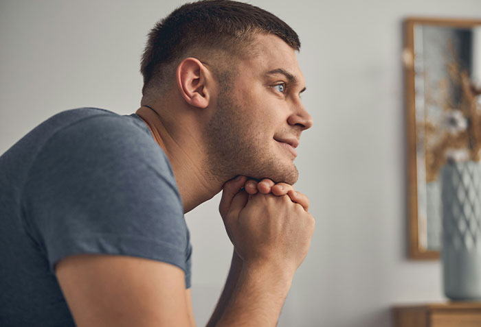Young man with a thoughtful expression, representing a long-time friend in a complex romantic situation.