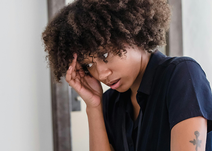 Young woman looking worried and stressed, hiding a secret about a one night stand from her boyfriend.
