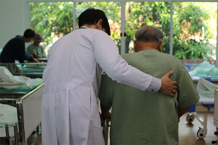Doctor comforting elderly man in hospital, reflecting sadness over family estrangement and niblings being brainwashed to hate him.