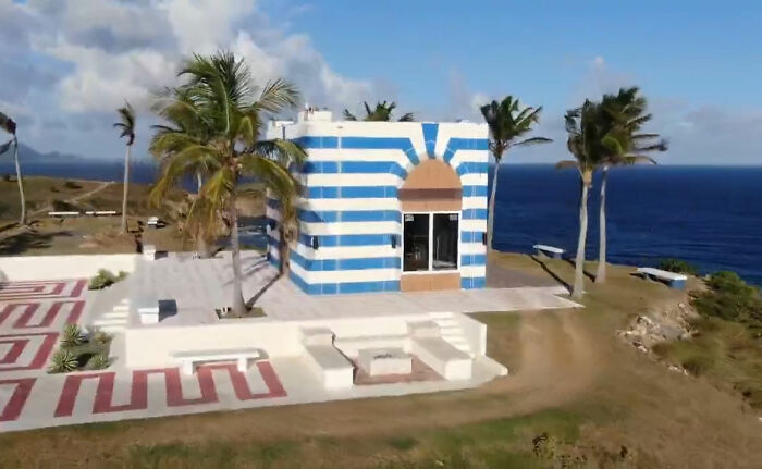 A striped blue and white seaside building surrounded by palm trees, representing interesting rabbit holes explored.
