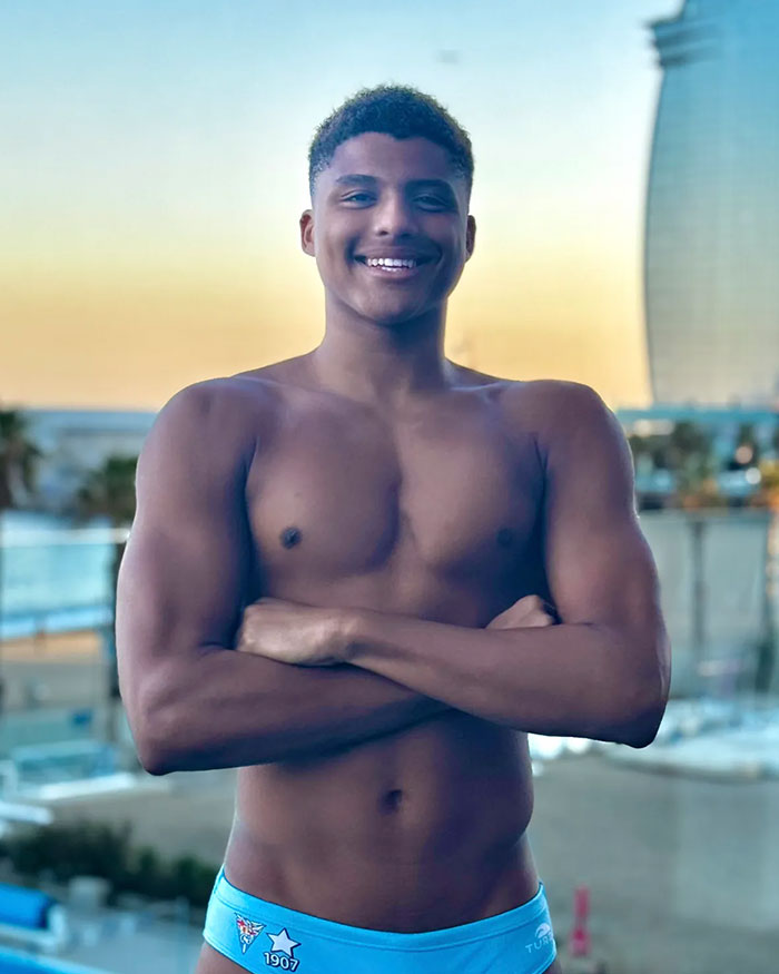 Star water polo player posing shirtless outdoors, smiling confidently with arms crossed against a beachside background. Star water polo player posing shirtless outdoors, smiling confidently with arms crossed against a beachside background.