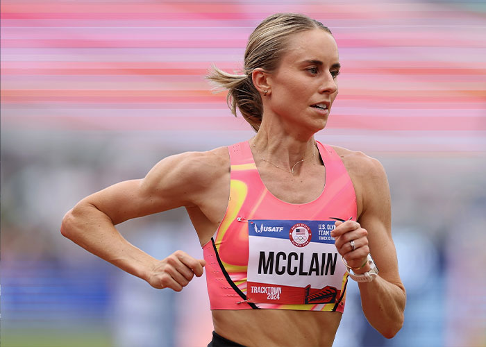 US track star McClain competing in a race, showing determination after losing title due to officials’ mistake and probe results.