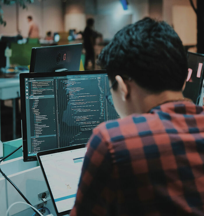 Person coding on a computer, focused on screen with programming code, illustrating moments people regretted opening their mouths.