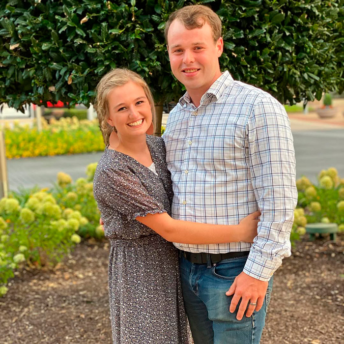 Young couple posing outdoors with greenery in the background; no mugshot or criminal charges shown related to Kendra Duggar.