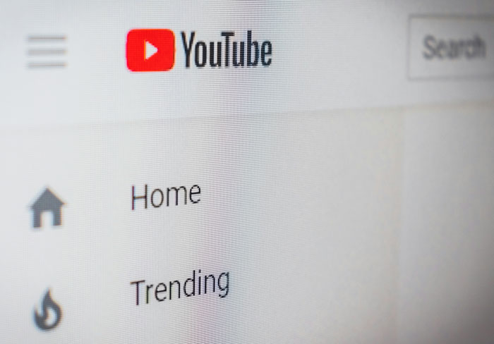 YouTube homepage menu showing trending and home options on a screen about harmless secrets between partners.
