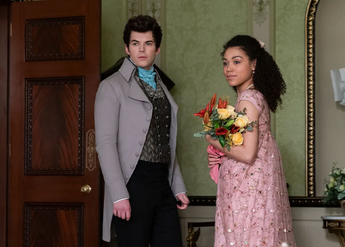 Bridgerton actress in period costume holding flowers, highlighting the impact of her mental health on her body.
