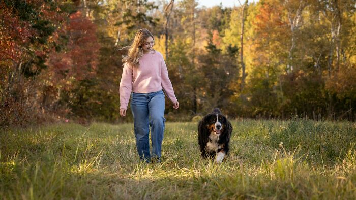 Young woman walking with her dog outdoors in autumn, reflecting on peer pressure.