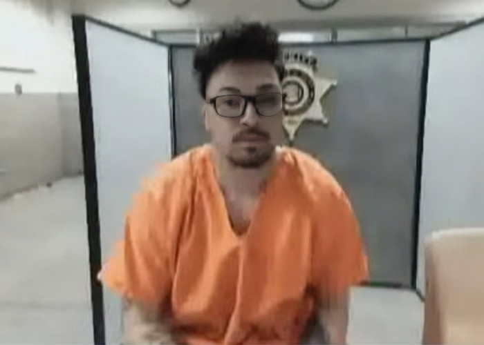 Homem com uniforme prisional laranja sentado em uma sala, parente de deputado acusado de sequestrar mulher em processo de custódia. Homem com uniforme prisional laranja sentado em uma sala, parente de deputado acusado de sequestrar mulher em processo de custódia.