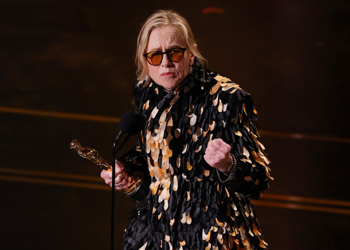 Woman holding an Oscar statuette on stage delivering an acceptance speech at the 2026 Academy Awards winners event.