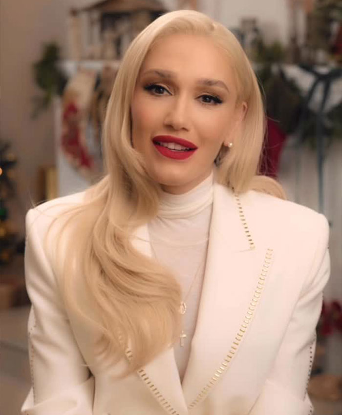 Gwen Stefani wearing a white blazer and turtleneck, addressing her Christian pivot and controversial anti-abortion app promotion.