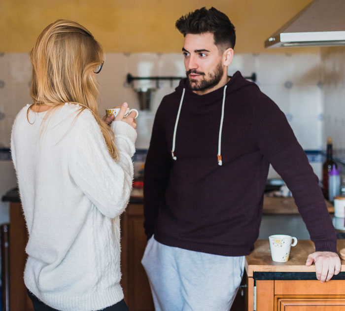 Woman with horrible feeling about her brother-in-law talking seriously with a man in a cozy kitchen setting. Woman with horrible feeling about her brother-in-law talking seriously with a man in a cozy kitchen setting.