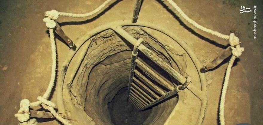 Entrance to an underground city showing a vertical ladder descending into ancient carved stone tunnels.