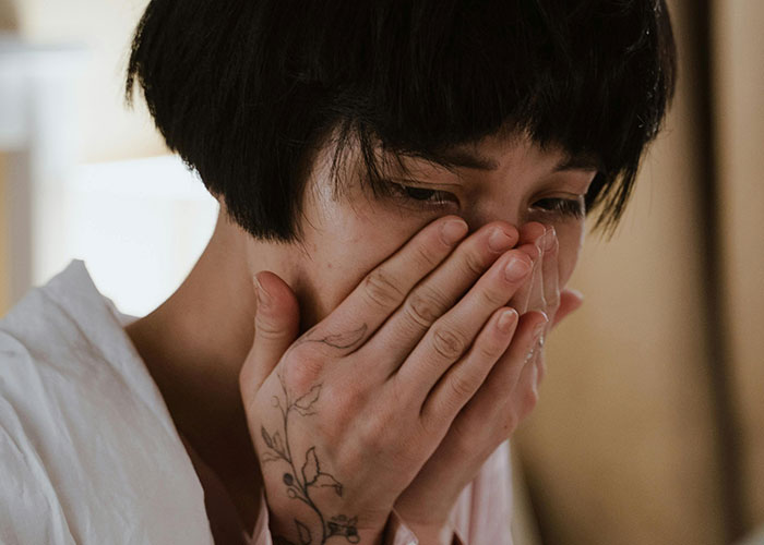 Close-up of an emotional person covering their mouth, reflecting the moment their ex revealed who they really were.