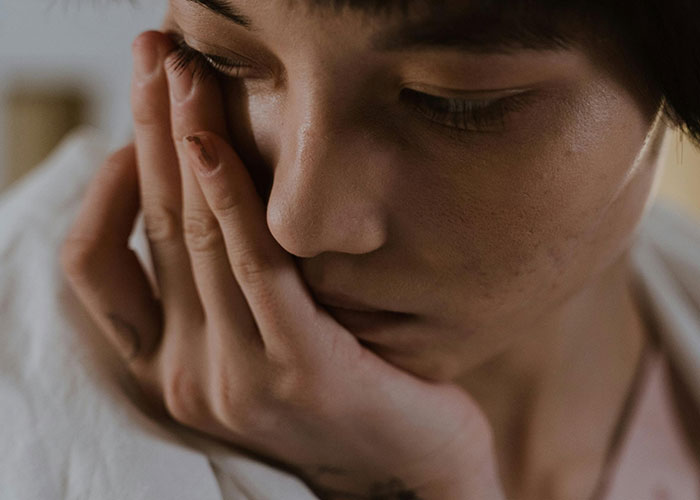 Close-up of a person with a troubled expression, reflecting the messiest love triangle and chaotic emotions.
