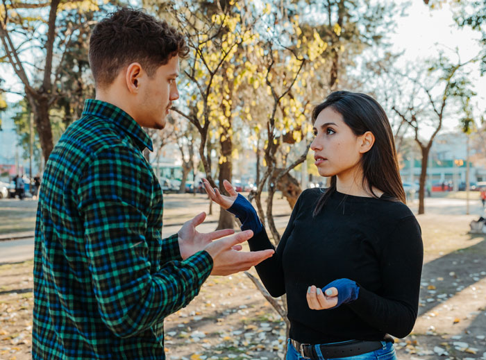 Two people outdoors having a serious conversation, illustrating people exposing shocking corporate secrets to customers.