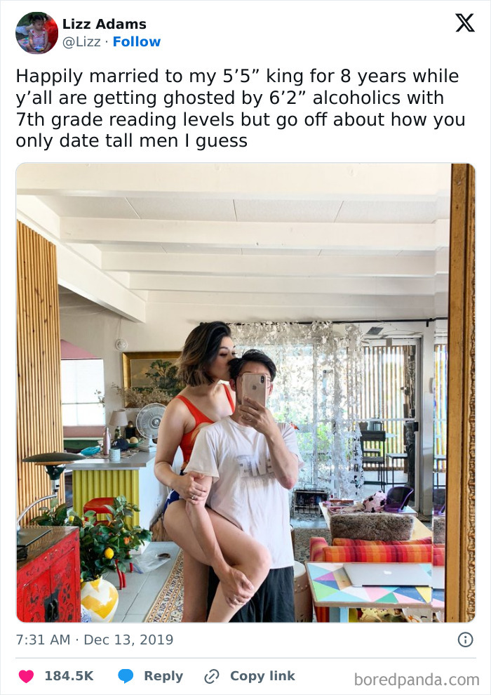 Couple taking mirror selfie in a cozy home, sharing a loving moment featured in internet's favorite moments.